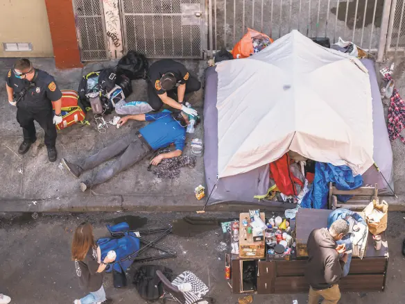  ?? Nick Otto / Special to The Chronicle 2020 ?? Paramedics work to revive an overdose victim in the Tenderloin in San Francisco last July.