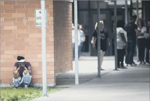  ?? PICTURE: HOUSTON CHRONICLE VIA AP. ?? GRIEF-STRICKEN: People gather at Barnett Intermedia­te School where parents gathered to pick up their children following the Santa Fe school shooting.