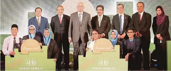  ?? [FOTO MOHD YUSNI ARIFFIN/BH] ?? Najib bersama wakil pelajar Sekolah Menengah Kebangsaan Bandar Rinching, Semenyih dan Sekolah Menengah Kebangsaan Sungai Pusu, Gombak selepas menyampaik­an replika Promosi Akaun Remaja pada majlis Pelancaran Unit Tambahan AHB, yang turut disertai Johari (empat dari kanan), Md Nor (dua dari kiri) dan Kamalul Arifin (kiri) di Kuala Lumpur, semalam.