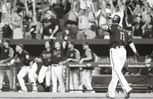  ?? AP ?? Manny Machado observa con el bate en la mano la trayectori­a de la pelota mientars el publíco en Baltimore festeja su su gran batazo.