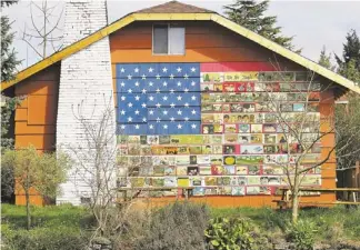  ?? PHOTOS BY CEDAR BURNETT/AP ?? Richard Ormbrek’s flag, made of about 180 tiles painted with Americana scenes, hasn’t lowered home values in his Seattle neighborho­od. In fact, he gets frequent offers to buy the house.