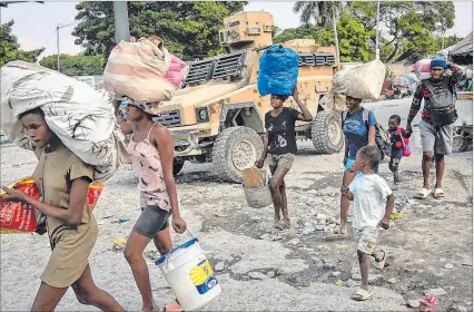  ?? ?? Puerto Príncipe. Personas abandonan sus hogares a causa de la guerra entre bandas en la zona de Pernier.
