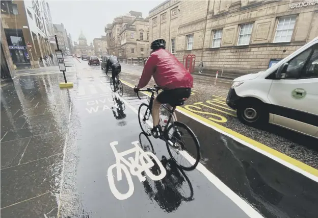  ??  ?? 0 More people have been encouraged to cycle during the Covid-19 crisis by separate lanes for bikes on busy roads such as this one on George IV Bridge in Edinburgh