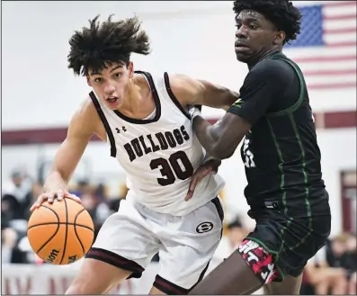  ?? (NWA Democrat-Gazette/Charlie Kaijo) ?? Springdale guard Isaiah Sealy (left) scored 33 points to lead the Bulldogs to a 57-48 nonconfere­nce victory over Kansas City (Mo.) Staley on Friday night at Bulldog Gym in Springdale.