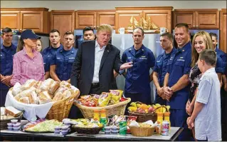  ?? GREG LOVETT / THE PALM BEACH POST ?? President Donald Trump visits the Coast Guard’s Lake Worth Inlet Station in Riviera Beach with first lady Melania Trump on Thanksgivi­ng, where he addresses Colin Gibson (right), who stands next to his mother, Jessica Gibson, and father, commanding...