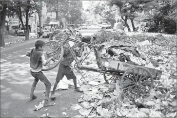  ?? Altaf Qadr
Associated Press ?? CHILDREN working as garbage collectors unload waste in New Delhi. A proposal to amend a child labor law would make it legal to employ children younger than 14 in “family enterprise­s” not deemed hazardous.