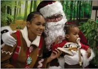  ?? PHOTO BY D. ROSS CAMERON ?? Santa Claus — portrayed by G. Antonio Larios — poses for a photograph with Crossroads High School student Sierra, left, and her 1-yearold son, Messiah, at the Mt. Diablo Unified School District's firstever HOPE (Homeless Outreach Proqram for Education) Holiday Fair on Tuesday in Concord.