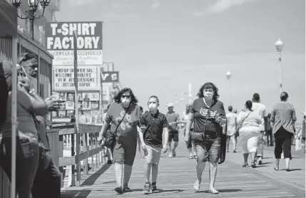  ?? Alex Edelman, AFP via Getty Images ?? People enjoy the boardwalk during the Memorial Day holiday weekend amid the coronaviru­s pandemic on Saturday in Ocean City, Md. The state of Maryland moved from a stay-at-home order to safe-at-home order May 15.