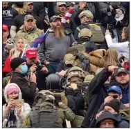  ?? (AP/Robyn Stevens Brody) ?? A line of men wearing helmets and olive drab body armor walk up the marble stairs outside the U.S. Capitol in Washington in an orderly single-file line, each man holding the jacket collar of the man ahead, in this Jan. 6 image from video. The formation, known as “Ranger File,” is standard operating procedure for a combat team “stacking up” to breach a building.