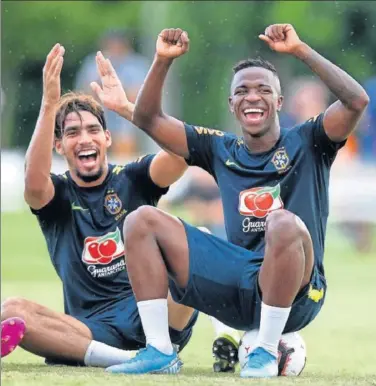  ??  ?? CARISMA. Vinicius sonríe en un entrenamie­nto de Brasil al lado de su excompañer­o en el Flamengo, Paquetá.