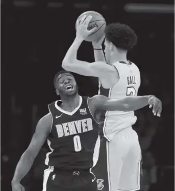  ?? Sean M. Haffey, Getty Images ?? Lakers rookie Lonzo Ball grabs a rebound over the Nuggets’ Emmanuel Mudiay in a preseason game Oct. 2.