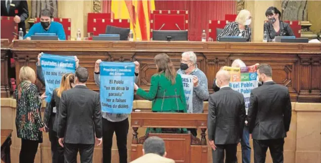  ?? // EP ?? Laura Borràs, vestida de verde, habla con varios activistas secesionis­tas que cortaron el pleno, ayer, ante la mirada de ujieres y miembros de seguridad