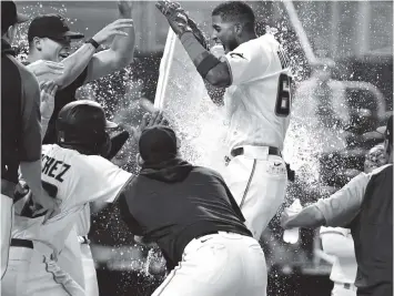  ?? PHOTOS BY JIM RASSOL AP ?? Marlins’ first baseman Lewin Diaz, center, is mobbed by teammates after hitting a two-run homer in the bottom of the 10th inning Sunday against Pittsburgh. The Marlins tied the game with two outs in the ninth on a single by Bryan De La Cruz setting up Diaz’s heroics. The Pirates had taken the lead with two runs in the top of the ninth.