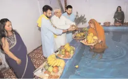  ?? — PTI ?? RJD chief Lalu Prasad Yadav with his sons Tej Partap, Tejaswi and wife Rabri Devi perform rituals during Chhath Puja celebratio­ns in Patna on Thursday.