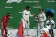  ?? ANTONIO CALANNI — THE ASSOCIATED PRESS ?? Mercedes driver Lewis Hamilton of Britain, center, celebrates on the podium with his teammate Mercedes driver Valtteri Bottas of Finland, right, after winning the Formula One Italy Grand Prix at the Monza racetrack, in Monza, Italy, Sunday.