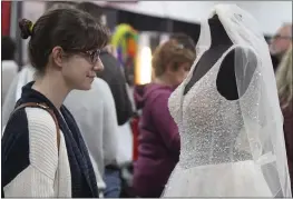  ?? MATHEW MIRANDA — ENTERPRISE-RECORD ?? Oroville resident Catherine Beagle looks at a wedding dress Sunday at the Chico Bridal Show at the Silver Dollar Fairground­s.