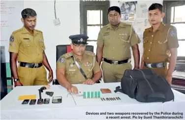  ??  ?? Devices and two weapons recovered by the Police during a recent arrest. Pic by Sunil Thanthiria­rachchi