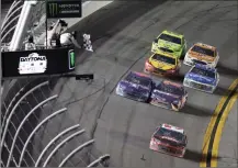  ??  ?? AUSTIN DILLON (3) TAKES THE CHECKERED FLAG to win the NASCAR Daytona 500 Cup series auto race at Daytona Internatio­nal Speedway in Daytona Beach, Fla., Sunday.