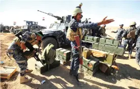  ??  ?? BAGHDAD: Iraqi policemen inspect their weapons at the Qayyarah military base, about 60 kilometres (35 miles) south of Mosul. — AFP