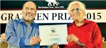  ??  ?? Mr. Arasanayag­am receives the award from Gratiaen Trust Chairman Walter Perera. Pic by Indika Handuwala