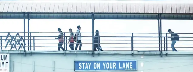  ?? PHOTOGRAPH­S BY YUMMIE DINGDING FOR THE DAILY TRIBUNE @tribunephl_yumi ?? COMMUTERS along Commonweal­th Avenue in Quezon City are using the overpass to ensure their safety while crossing to the other side of the road on a busy Wednesday morning.