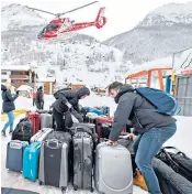  ??  ?? Members of the ski patrol use dynamite to trigger avalanches under controlled conditions, right; left, tourists evacuated from the resort of Zermatt by helicopter recover their luggage in nearby Täsch