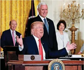  ?? [AP PHOTOS] ?? President Donald Trump gestures Monday as he signs a “Space Policy Directive” during a meeting in the East Room of the White House as Vice President Mike Pence watches.