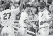  ?? NATI HARNIK/AP ?? Florida's JJ Schwarz, right, is greeted by Jonathan India and Nelson Maldonado (27) after his two-run homer against Texas Tech in the sixth inning on Thursday night. College World Series schedule, 5C.