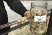  ?? SEAN MURPHY — THE ASSOCIATED PRESS ?? Ethan McKee, vice president of Mango Cannabis, displays marijuana flowers at a dispensary in Oklahoma City on Tuesday.