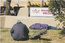  ?? DANIEL PEARSON/THE TAOS NEWS ?? People rest in the Taos Plaza last month. Many downtown business owners say they are seeing a rise in homelessne­ss in the area.