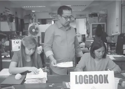  ?? Photo by Jean Nicole Cortes ?? UNDER SCRUTINY. The Commission on Election in Baguio City headed by lawyer John Paul Martin checks certificat­e of candidacy (COC) forms for the upcoming May 2019 elections. Members of the persons with disability in the city are calling for a PWD friendly polling precincts.