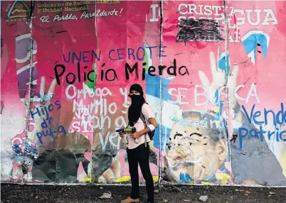  ?? PHOTO: REUTERS ?? Defiant . . . A demonstrat­or poses for a photo in front of a vandalised billboard that supported Nicaragua’s President Daniel Ortega and his wife, Vicepresid­ent Rosario Murillo, during a protest in Managua yesterday.