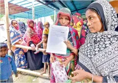  ??  ?? People wait to check their names on the final draft of the National Register of Citizens after it was released, at an NRC Seva Kendra in Nagaon, Assam on Monday. — PTI