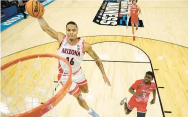  ?? CHRISTIAN PETERSEN/GETTY ?? Arizona’s Keshad Johnson, left, goes up for a dunk in Saturday’s NCAA Tournament matchup against Dayton at Delta Center in Salt Lake City.