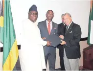  ??  ?? High commission­er of the Federal Republic of Nigeria, Olatokunbo Kamson (left) is presented with a parting gift by diplomatic corps head José Tomas Ares German (right) and Arnaldo Brown, minister of state in the Ministry of Foreign Affairs and Trade.