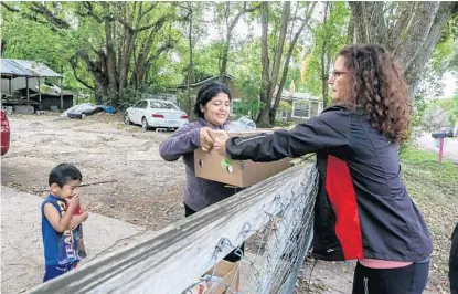  ?? SARAH ESPEDIDO/STAFF PHOTOGRAPH­ER ?? Volunteer Patti McKeever surprises Damaris Bamaca with four boxes of food donations on Sunday.