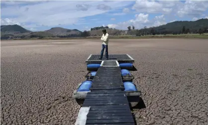  ?? Photograph: Raúl Arboleda/AFP/Getty Images ?? A Colombian engineer, Hernán Sandino, stands on a dock in the Suesca lagoon, which has dried updue to a strong drought exacerbate­d by climate change.