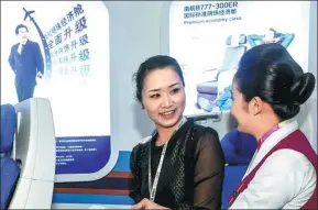  ?? XINHUA ?? An employee (right) of China Southern Airlines introduces the airline's services to a visitor at an industry expo in Zhuhai, Guangdong province.