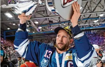  ?? Foto: Sven Hoppe, dpa ?? Der aus Füssen stammende EHC Kapitän Michael Wolf präsentier­t den Münchner Fans den Pokal. Am Samstag will die Mann schaft zusammen mit den Anhängern die Meistersch­aft feiern.