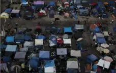  ??  ?? A large homeless encampment is formed in the Santa Ana Civic Center on Oct. 11 in Santa Ana. The number of homeless living in Orange County has climbed 8 percent over the last two years. AP PHOTO/ JAE C. HONG