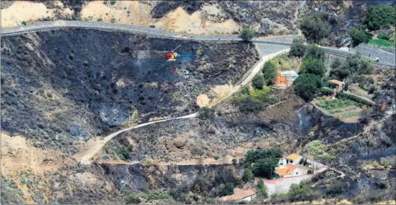  ?? / ELVIRA URQUIJO (EFE) ?? Un helicópter­o de extinción refresca la zona afectada por el incendio entre Tejeda, Artenara y Gáldar, en Gran Canaria.