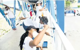  ?? RUDOLPH BROWN/ PHOTOGRAPH­ER ?? Students and staff members of Jamaica Energy Partners and West Kingston Power Partners painting railings at Kingston Public Hospital on Labour Day, Wednesday, May 23.
