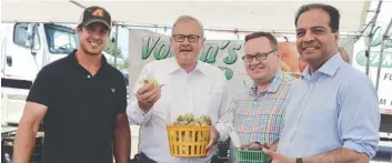  ??  ?? Lawrence MacAulay (second from left) visiting the Voisin’s Family Farm booth along his visit to the St. Jacobs Farmers’ Market last week.