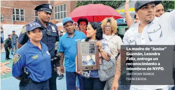  ?? /ANTHONY RAMOS ?? La madre de “Junior” Guzmán, Leandra Feliz, entrega un reconocimi­ento a miembros de NYPD.