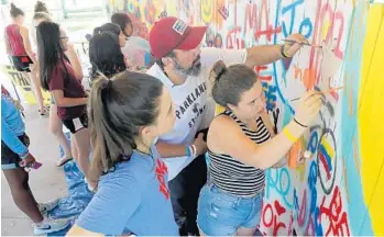  ?? MIKE STOCKER/STAFF PHOTOGRAPH­ER ?? Andrea Pena and Sawyer Garrity help paint a “graffiti wall” during an art class taught by Manuel Oliver during the first week of Camp Shine at Pine Trails Park in Parkland.