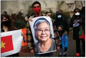  ?? (AP/Thibault Camus) ?? An activist holds a picture of Tran To Nga, a 78-year-old former journalist, during a Saturday gathering in Paris in support of people exposed to Agent Orange during the Vietnam War. More photos at arkansason­line.com/131orange/.