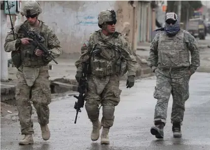  ?? Allauddin Khan / Associated Press file ?? U.S. soldiers walk with their Afghan translator near the scene of a suicide attack in Kandahar.