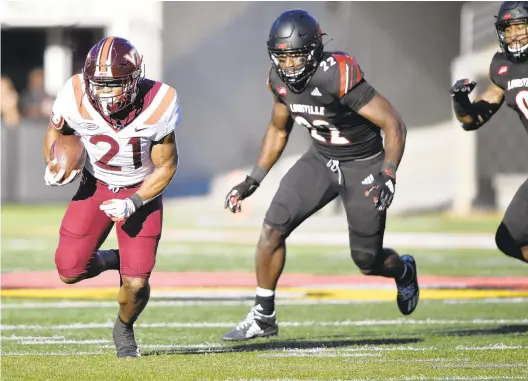  ?? JAMIE RHODES / ACC MEDIA ?? Virginia Tech running back Khalil Herbert finds a lane in Saturday’s first half against Louisville at Cardinal Stadium. He ran for 147 yards and a touchdown on 21 carries.