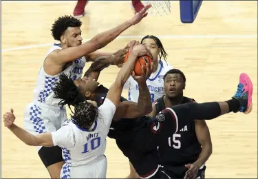  ?? Associated Press ?? Tangled up: South Carolina's Trae Hannibal, center, has his shot blocked by Kentucky's Davion Mintz (10) and Olivier Sarr, top left, during the first half of an NCAA college basketball game in Lexington, Ky., Saturday.