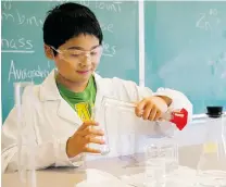  ?? JENELLE SCHNEIDER/PNG FILES ?? John Lim, 13, joins fellow students in the chemistry lab for an experiment as part of the university transition program at UBC.